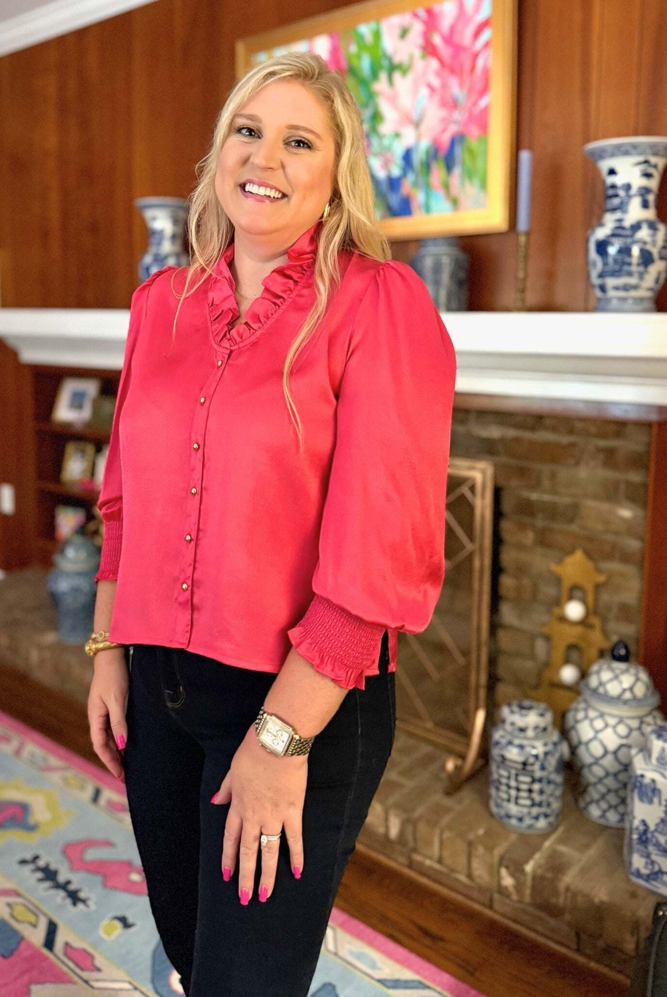 Woman wearing pink Harper Top long sleeve with ruffle neckline and gold buttons indoors